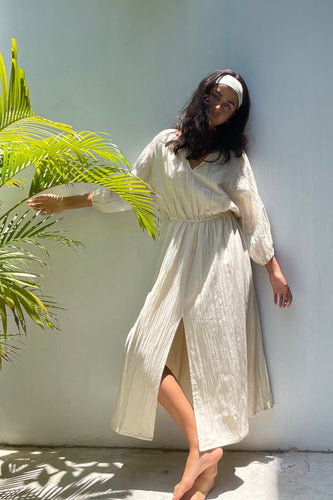 A lightweight dark pale cream midi length dress in a silk/cotton blend. Front split, balloon sleeves and a tie belt. Perfect resort wear and city wear.